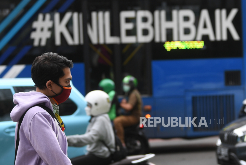 Warga mengenakan masker saat melintas di Jalan MH Thamrin, Jakarta, Rabu (12/1/2022). Kemenkes memprediksi puncak penyebaran kasus COVID-19 varian Omicron akan terjadi pada awal atau pertengahan Februari 2022. 
