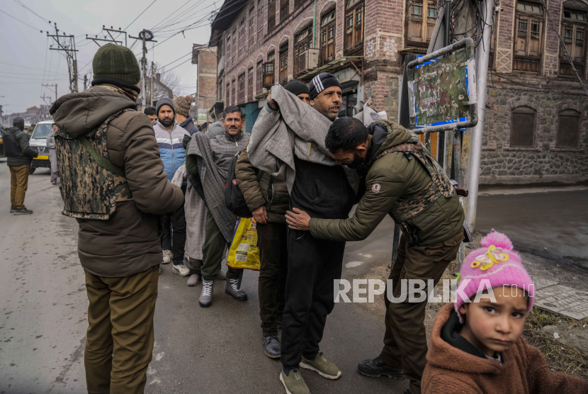 Seorang anak melihat polisi India menggeledah pejalan kaki Kashmir selama pemeriksaan keamanan mendadak di Srinagar, Kashmir yang dikuasai India, Senin, 9 Januari 2023.