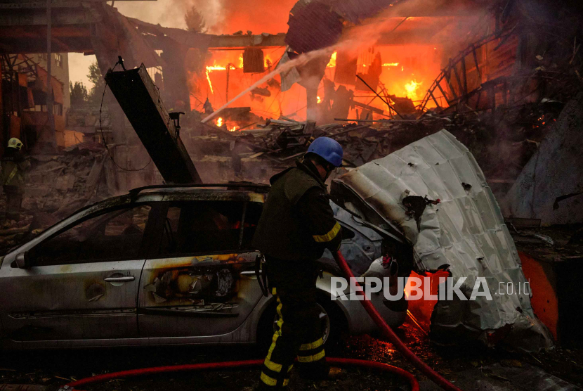 Petugas pemadam kebakaran berusaha memadamkan api yang membakar gedung di lokasi jatuhnya rudal Rusia yang menargetikan ibu kota Kyiv, Ukraina, Rabu (30/8/2023). Pasukan Rusia melancarkan serangan dengan target ibu kota Ukraina Kyiv.