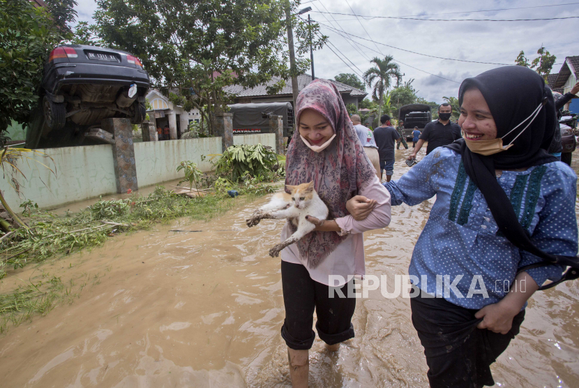  Wanita membawa kucing liar yang diselamatkan, di daerah yang terkena banjir di Medan, Sumatera Utara. Pemkot Medan siap menggandeng Kementerian PUPR untuk membangun tembok laut.