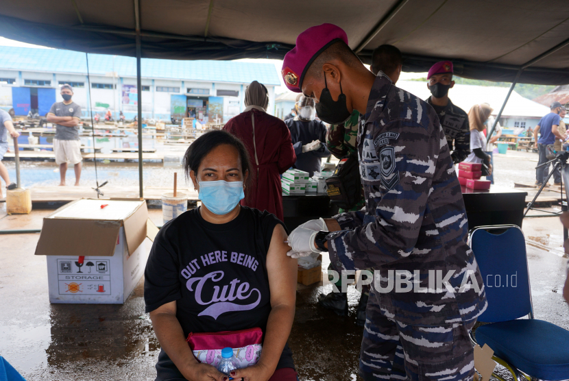 Tenaga Kesehatan TNI AL saat menyuntikkan vaksinasi kepada warga masyarakat maritim di Pasar Ikan Jembatan Puri Kota Sorong, Papua Barat.  Mabes TNI mengirimkan 50 tabung oksigen, dan 50 konsentrator, serta 1.000 APD, dan 120 ribu lembar masker