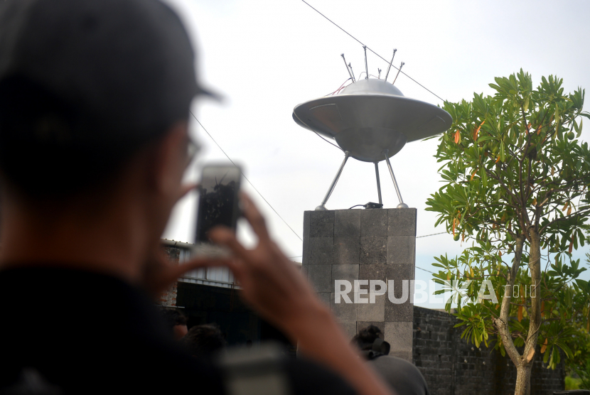 Pengunjung memotret Monumen Crop Circle atau Monumen UFO di Berbah, Sleman, Yogyakarta. 
