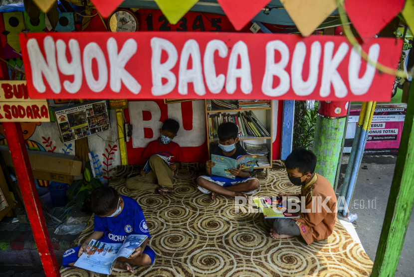 Anak-anak saat membaca buku di Bale Buku, Gang Dendrit, Cakung, Jakarta, Jumat (4/6). Bale Buku yang memanfaatkan tempat pos ronda itu menjadi sarana edukasi, bermain dan belajar, yang bertujuan untuk meningkatkan literasi anak-anak di lingkungan Gang Dendrit.