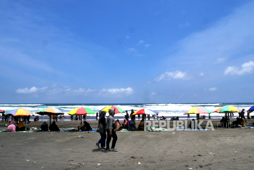 Warga berwisata di Pantai Parangtritis, Bantul, Yogyakarta, Ahad (10/10). Pantai Parangtritis ramai dikunjungi warga meski status belum dibuka sejak PPKM Darurat lalu. Sehingga pengunjung masuk tanpa ada membayar retribusi masuk kawasan pantai. Tetapi, ekonomi bergeliat imbas ramainya pengunjung pada akhir pekan.