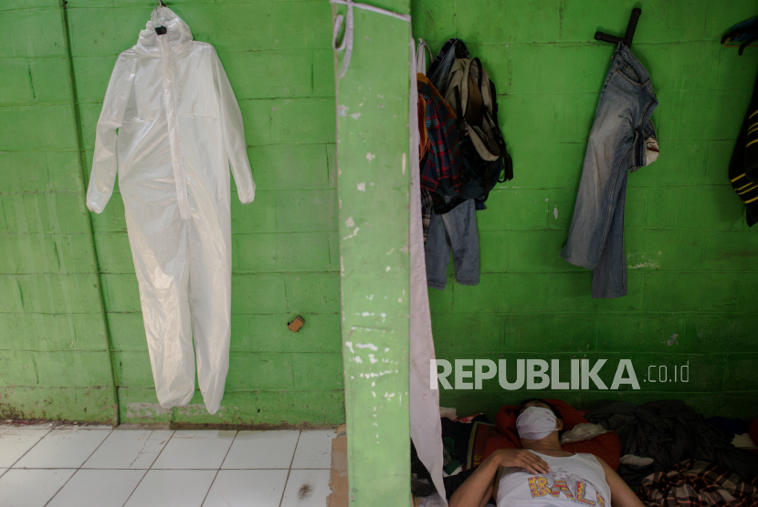 Pekerja beristirahat usai menyelesaikan pembuatan pakaian untuk alat pelindung diri tenaga medis di Pusat Industri Kecil, di kawasan Penggilingan, Jakarta Timur, Rabu (25/3). Industri pakaian APD berbahan parasut tersebut dijual dengan harga Rp