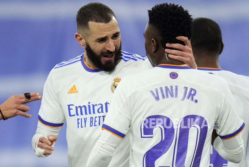 Striker Real Madrid Karim Benzema merayakan gol dengan rekan setimnya Vinicius Junior (kanan).