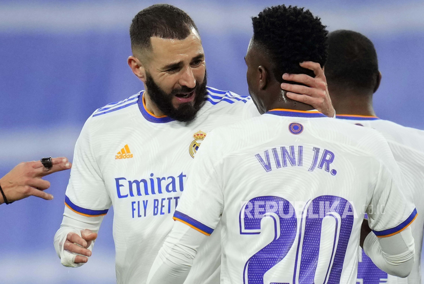 Pemain Real Madrid Karim Benzema merayakan dengan rekan setimnya Vinicius Junior, setelah mencetak gol pertama timnya selama pertandingan sepak bola La Liga Spanyol antara Real Madrid dan Sevilla di stadion Bernabeu di Madrid, Spanyol, 28 November 2021.