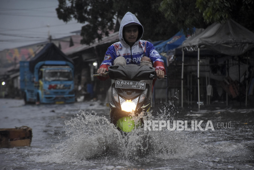 Pengendara melintasi genangan banjir di Pasar Gedebage, Bandung, Jawa Barat, Jumat (1/12/2023). Kawasan tersebut kerap dilanda banjir akibat drainase yang buruk saat intensitas curah hujan yang tinggi. Genangan banjir tersebut mengganggu akses lalu lintas dan merendam sebagian kawasan Pasar Gedebage.