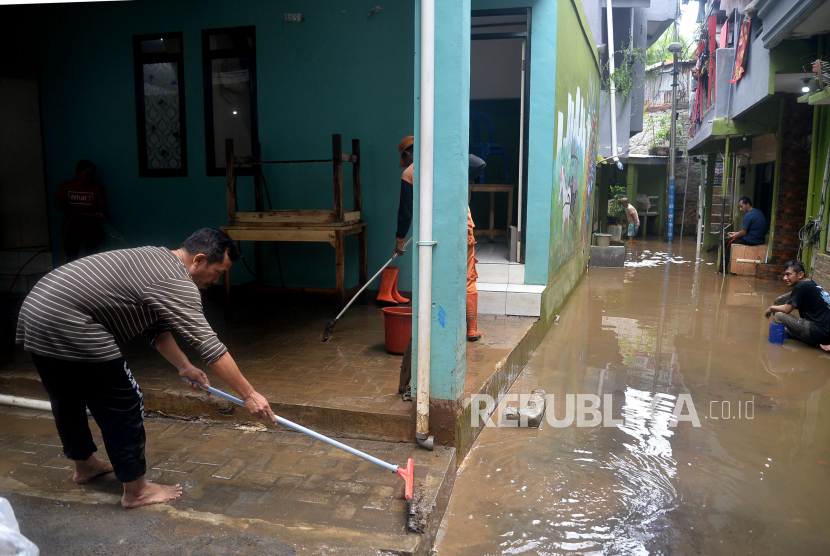 Warga membersihkan lumpur sisa banjir yang terjadi di Kebon Pala, Kelurahan Kampung Melayu, Jakarta Timur, Sabtu (16/7/2022).