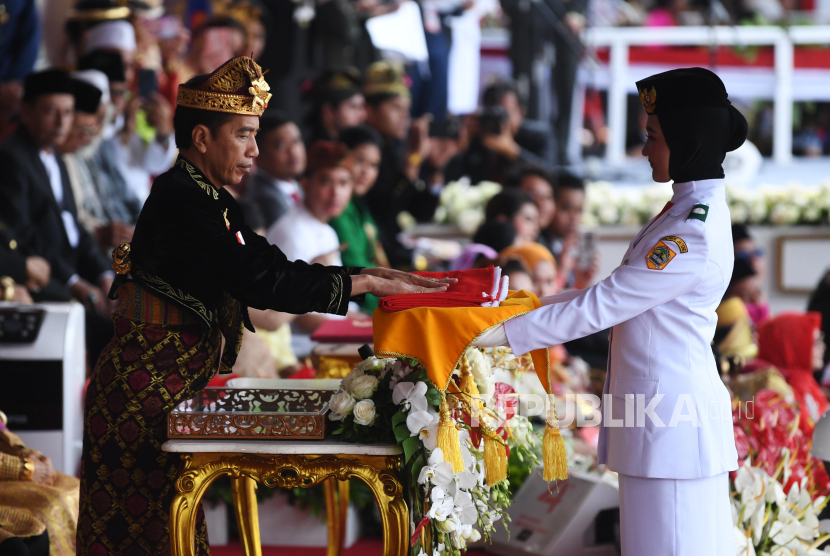 Presiden Joko Widodo menyerahkan duplikat bendera pusaka kepada Paskibraka Tarrisa Maharani Dewi saat  Upacara Peringatan Detik-Detik Proklamasi Kemerdekaan Indonesia ke-74 Tahun 2019 di Istana Merdeka, Jakarta, Sabtu (17/8/2019). ANTARA FOTO/Wahyu Putro A/foc.