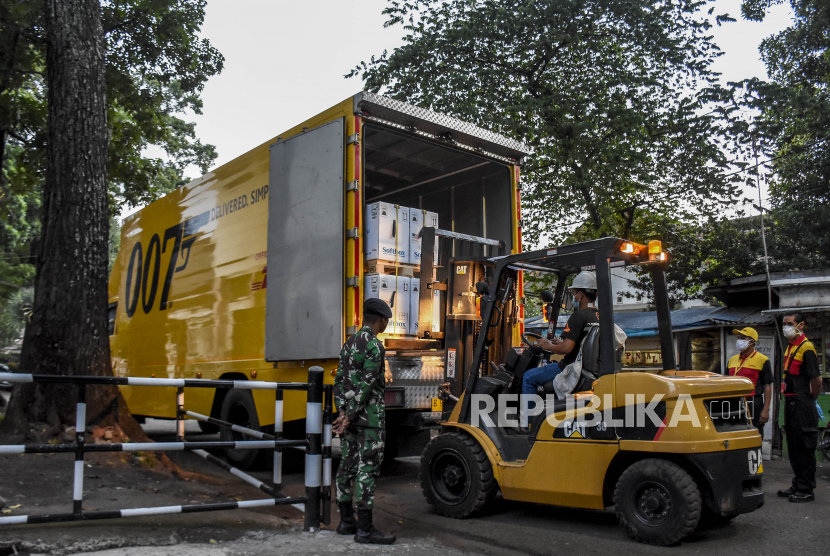 Petugas melakukan bongkar muat paket berisi vaksin Covid-19 Pfizer setibanya di PT Bio Farma (Persero), Jalan Pasteur, Kota Bandung, Jumat (17/9). Sebanyak 1.755.000 ribu dosis vaksin Covid-19 Pfizer tiba di Indonesia melalui skema kerja sama bilateral dose sharing dengan pemerintah Amerika Serikat. Vaksin Pfizer tersebut nantinya akan dialokasikan untuk program vaksinasi nasional yang menyasar 208.265.720 penduduk. Foto: Republika/Abdan Syakura