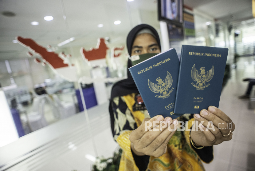 Petugas Imigrasi menunjukkan paspor milik pemohon di Kantor Imigrasi Kelas I Non TPI Jakarta Selatan, Jumat (25/9/2020).
