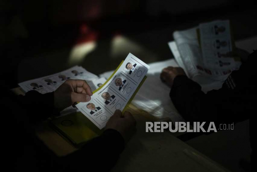Petugas pemilu menyiapkan surat suara di sebuah tempat pemungutan suara di tempat pemungutan suara di Istanbul, Turki,  Ahad, (14/5/2023).