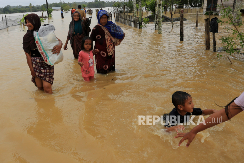 Warga menyelamatkan harta benda dari banjir di Aceh. Komnas Perempuan sebut dampak bencana 14 kali lebih berat bagi perempuan.