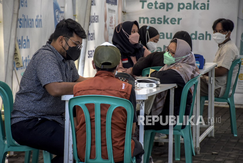 Sejumlah warga menjalani pemeriksaan kesehatan sebelum disuntik vaksin Covid-19 saat pelaksanaan vaksinasi Covid-19 massal di Taman Dewi Sartika, Jalan Wastukencana, Kota Bandung, Jumat (8/4/2022). Dinkes Kota Bandung mendirikan pos vaksinasi saat mudik lebaran.