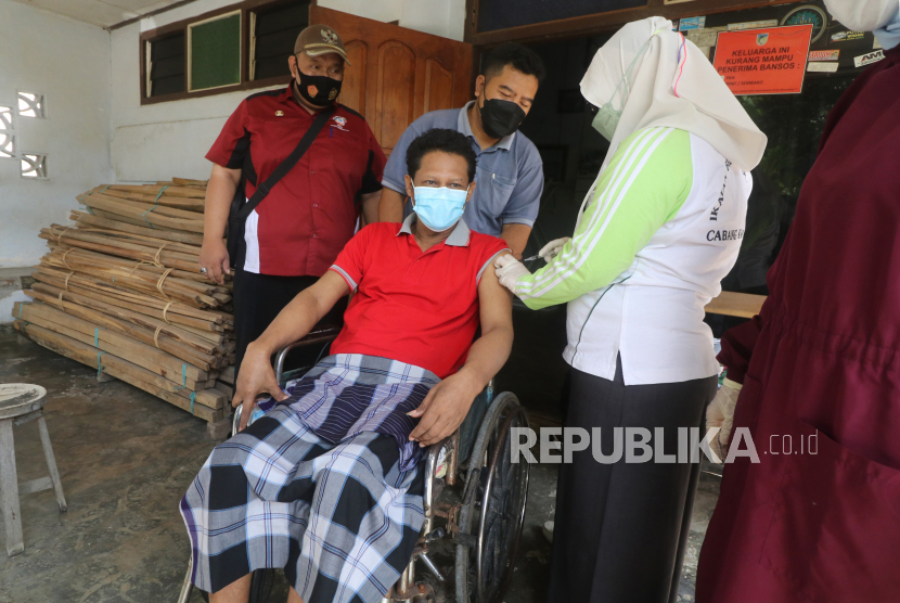 Petugas kesehatan menyuntikkan vaksin COVID-19 kepada penyandang disabilitas di Desa Srikaton, Kediri, Jawa Timur, Jumat (1/10/2021). Vaksinasi COVID-19 dosis ke dua secara jemput bola tersebut guna memberikan kemudahan layanan kepada penyandang disabilitas yang kesulitan mendatangi lokasi vaksinasi. 