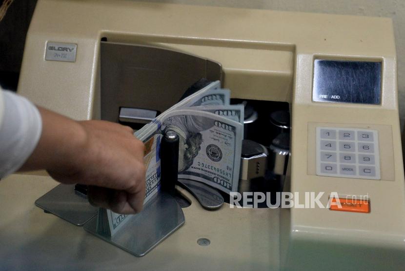 Karyawan menghitung uang di salah satu gerai penukaran uang asing di Jakarta, Rabu (6/5/2020).