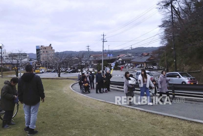  Masyarakat berjalan ke tempat lebih tinggi untuk berlindung setelah gempa di Wajima, Prefektur Ishikawa, Senin (1/1/2024). 