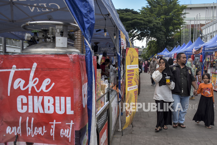 Sejumlah warga berjalan di samping lapak penjual jajanan chiki ngebul (cikbul). Dinkes Jawa Timur membentuk tim investigasi untuk menelusuri peredaran chiki ngebul.