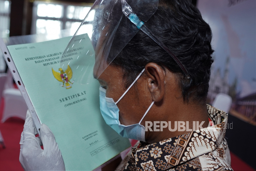 Warga mencium sertifikat usai mengikuti penyerahan sertifikat tanah gratis oleh Presiden Joko Widodo secara virtual pada Selasa (5/1) (ilustrasi). 