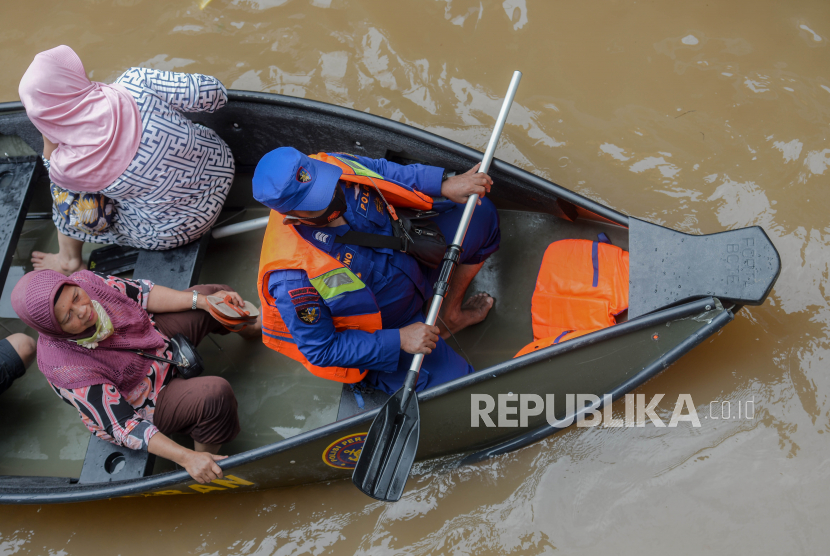Warga menaiki perahu saat melintasi banjir yang merendam kawasan Cipinang Melayu, Jakarta Timur, Jumat (19/2). Banjir yang terjadi akibat  luapan Kali Sunter tersebut menggenangi sebanyak lima Rukun tetangga diantaranya RT 01 hingga RT 05 yang bread di RW 04 dengan ketinggian 90 centimeter.
