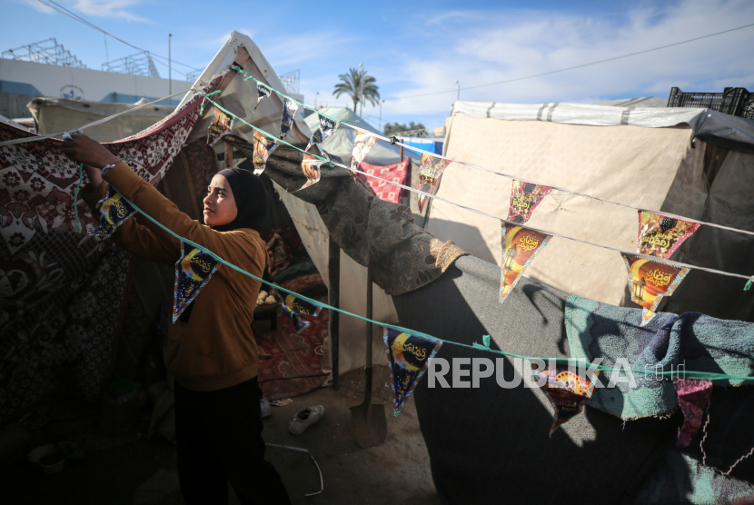 Pengungsi Palestina memasang dekorasi di tenda pengungsian mereka saat menyambut datangnya Ramadhan di Rafah, di selatan Jalur Gaza.