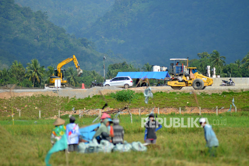 Pekerja mengoperasikan alat berat saat melanjutkan pembangunan jalan tol di Nagari Buayan, Padang Pariaman, Sumatera Barat, Ahad (28/1/2024). 