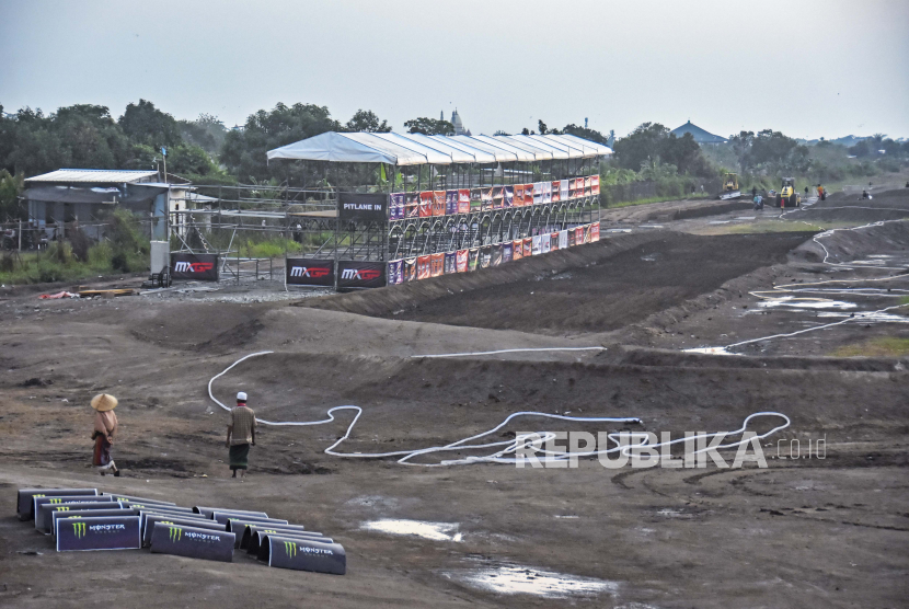 Dua orang warga melintas di area tribun pembangunan sirkuit Motocross Grand Prix (MXGP) di bekas Bandara Selaparang, Mataram, NTB, Senin (26/6/2023). 