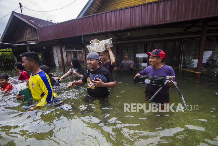 Warga menyelamatkan barang dari rumah yang terendam banjir di Desa Banua Raya di Kabupaten Tanah Laut, Kalimantan Selatan, Senin (11/1/2021). Berdasarkan data yang telah di himpun aparat desa Banua Raya, sebanyak 2.907 Jiwa terdampak banjir akibat luapan sungai Bati Bati. 