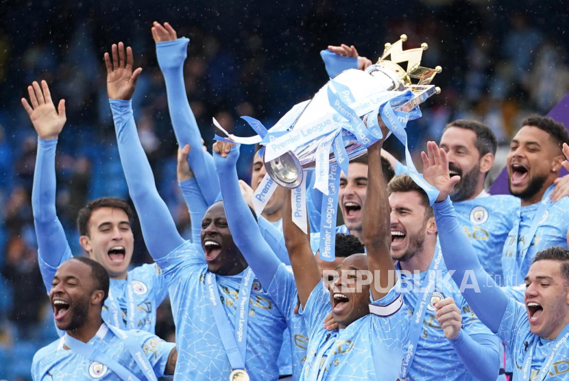 Manchester City mengangkat trofi setelah memenangkan Liga Premier Inggris, Ahad (23/5).
