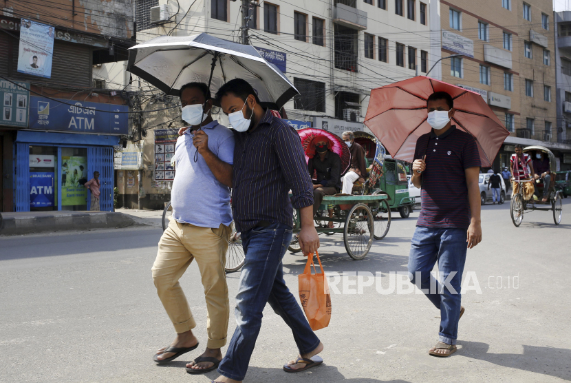 Sejumlah warga menggunakan payung untuk melindungi diri dari gelombang panas di Dhaka, Bangladesh, Selasa (27/4). Gelombang panas yang terjadi di Bangladesh itu merupakan yang terparah semenjak tujuh tahun terakhir dengan suhu tertinggi mencapai 41,2 derajat celcius dan diperkirakan akan berlangsung hingga 30 April 2021.  EPA-EFE/MONIRUL ALAM