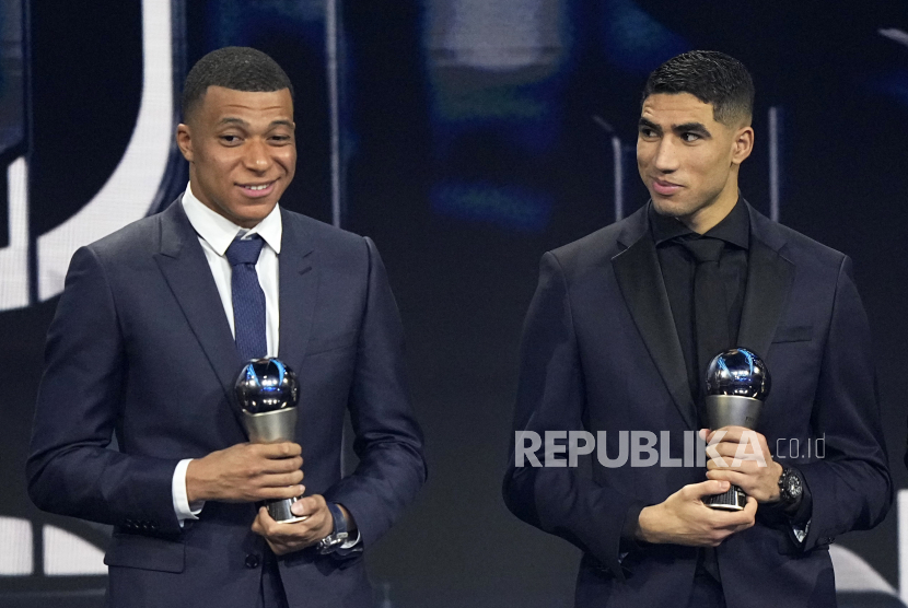 Kylian Mbappe, left, and Achraf Hakimi, pose with trophies Men