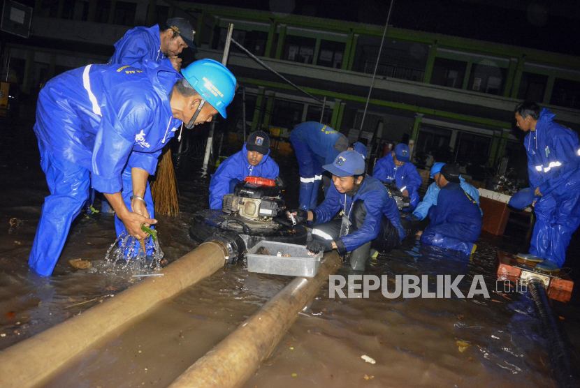 Sejumlah petugas Suku Dinas Sumber Daya Air Jakarta Selatan  penyedotan air yang menggenangi MTsN 19 Jakarta di Pondok Labu, Jakarta, Kamis (6/10/2022). Sebanyak tiga siswa meninggal tertimpa tembok yang roboh akibat terjangan banjir yang menggenangi sekolah tersebut. 