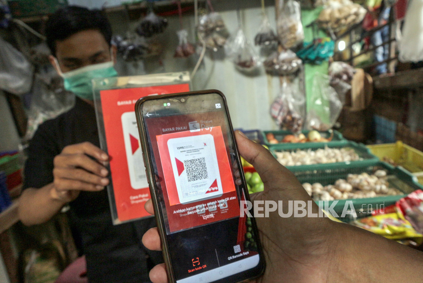 Warga bertransaksi digital menggunakan Quick Response Code Indonesian Standard (QRIS) saat berbelanja (ilustrasi). Bank Indonesia (BI) menaikan batasan transaksi QRIS per hari menjadi Rp 10 juta dari Rp 5 juta saat ini. 