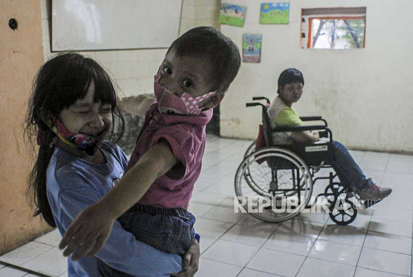 Anak-anak memakai masker saat bermain di Rusun Bidara Cina, Jatinegara, Jakarta, Kamis (19/11). Anak yang punya sistem kekebalan tubuh lemah (immunocompromised) direkomendasikan untuk melindungi diri dengan memakai masker bedah.
