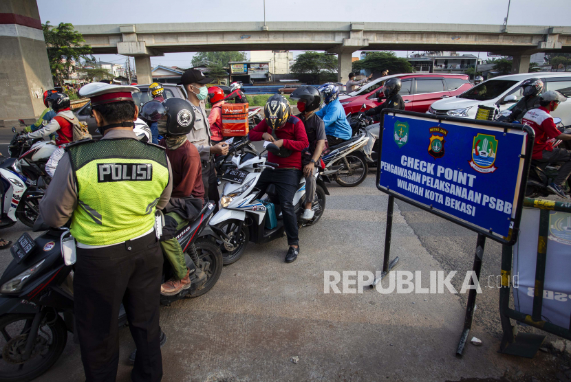 Petugas melakukan pengawasan terhadap kendaraan yang melintasi Check Point Pembatasan Sosial Berskala Besar (PSBB) di kawasan Kalimalang, Bekasi, Jawa Barat, Rabu (13/5/2020). Dalam pengawasan tersebut petugas menghimbau masyarakat untuk menggunakan masker saat berpergian dan mengatur posisi duduk serta pembatasan penumpang untuk kendaraan pribadi maupun angkutan umum