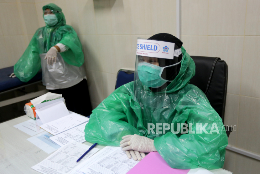 Petugas medis Puskesmas Ulee Kareng memakai jas hujan plastik sebagai pengganti alat pelindung diri (APD) saat melayani pasien berobat (ilustrasi).