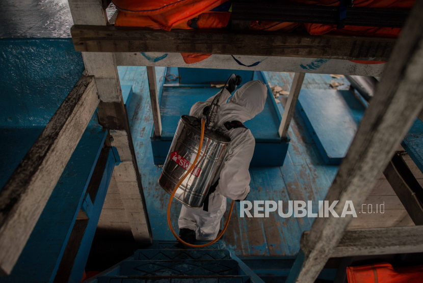 Petugas Dit Polair menyemprotkan cairan disinfektan di kapal penumpang di Pelabuhan Kaliadem, Muara Angke Jakarta, Jumat (19/6). Penyemprotan dilakukan di area pelabuhan dan kapal-kapal saat penerapan PSBB transisi setelah dibuka kembali jalur penyeberangan ke pulau seribu guna mengantisipasi penyebaran COVID-19 di kawasan tersebut