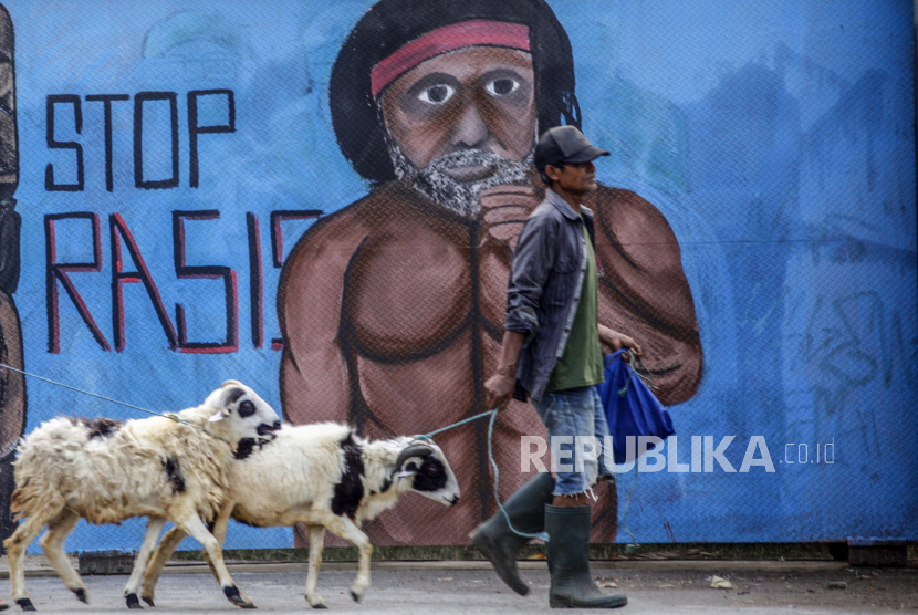 Warga melintas di depan mural bertema Anti Rasisme  di Jalan Raya Bogor, Cilodong, Depok, Jawa Barat,  Selasa (28/7/2020). Mural tersebut dibuat untuk mengkampanyekan gerakan anti rasisme serta sebagai media edukasi masyarakat . ANTARA FOTO/Yulius Satria Wijaya/hp.