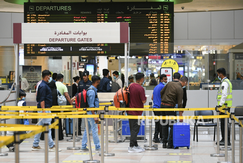  Penumpang berjalan di gerbang keberangkatan di bandara internasional Kuwait di Kota Kuwait, Kuwait, Ahad (24/10). Kuwait melanjutkan operasi penuh Bandara Internasional Kuwait pada 24 Oktober karena negara tersebut semakin melonggarkan pembatasan covid-19.