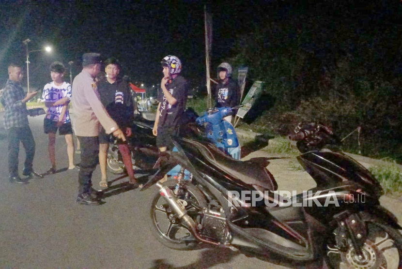 Polisi menghampiri sejumlah orang yang kedapatan membawa sepeda motor berknalpot brong. Polda Jabar menyita sebanyak 17 ribu knalpot brong dalam 9 hari razia.