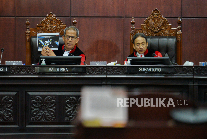 Ketua MK  Suhartoyo (kanan) dan Hakim MK Saldi Isra (kiri) menunjukan peta pembagian bansos yang di lakukan presiden saat sidang lanjutan sengketa hasil Pilpres 2024 di Mahkamah Konstitusi, Jakarta, Jumat (5/4/2024). MK memanggil empat Menteri kabinet Jokowi-Maruf dalam sidang lanjutan PHPU Pilpres 2024 yakni Menko PMK, Menko Perekonomian, Menkeu dan Mensos.