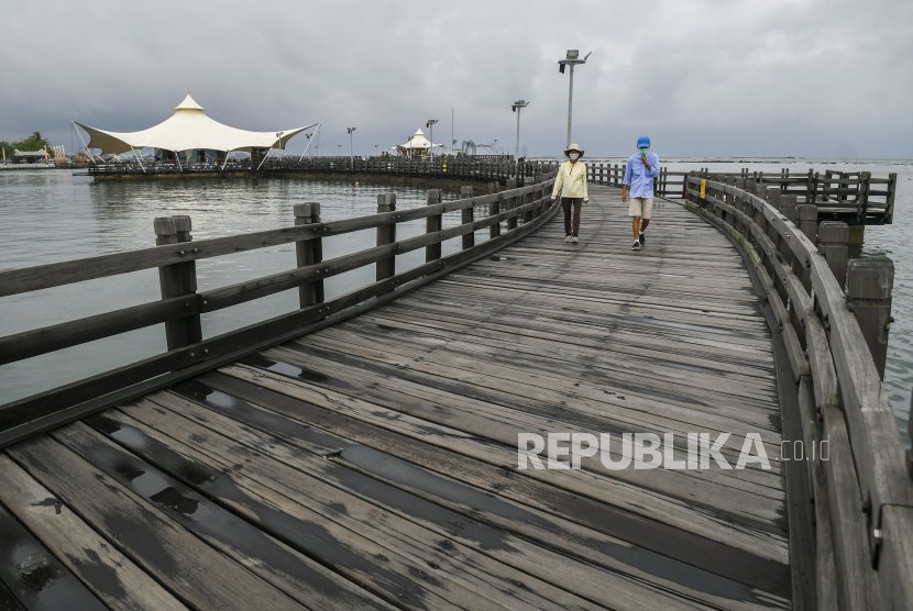 Pengunjung berjalan di kawasan wisata Ancol, Jakarta, Selasa (16/2). Perusahaan Badan Usaha Milik Negara (BUMN) siap bersinergi untuk membangkitkan pariwisata. 