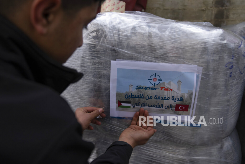 Seorang pekerja menempel stiker bertuliskan donasi dari Palestina untuk rakyat Turki, sementara dia menyiapkan kiriman perlengkapan tidur untuk para korban gempa bumi di Turki dan Suriah yang sekarang terkena cuaca musim dingin yang membekukan, di sebuah pabrik Palestina di Kota Hebron di Tepi Barat, Kamis (16/2/2023). Warga Palestina telah turun tangan untuk membantu mereka yang terhuyung-huyung akibat gempa dahsyat di Turki dan Suriah, dengan Otoritas Palestina bahkan mengirimkan tim medis dan ahli lainnya untuk mendukung penyelamatan Turki dan Suriah upaya.