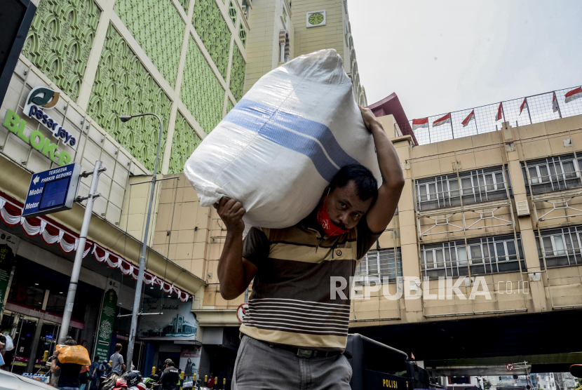 Kuli panggul saat beraktivitas di Pasar Tanah Abang, Jakarta, Rabu (16/9). Pada PSBB kali ini, Pemerintah Provinsi DKI Jakarta tetap memberikan izin pasar atau kawasan niaga untuk beroperasi dengan tetap menerapkan protokol kesehatan yang ketat. Republika/Putra M. Akbar