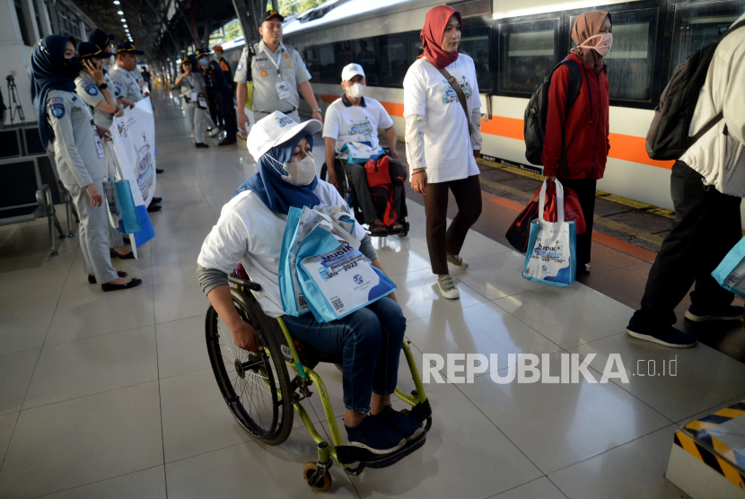 Sejumlah peserta mudik penyandang disabilitas berjalan menuju rangkaian kereta api di Stasiun Pasar Senen, Jakarta, Ahad (16/4/2023). 