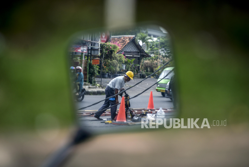 Petugas PLN memperbaiki jaringan kabel listrik yang menjuntai ke jalan di Jalan Pemuda, Kota Bogor, Jawa Barat, Jumat (27/1/2023). PT Perusahaan Listrik Negara (Persero) atau PLN membukukan pendapatan usaha sebesar Rp 455 triliun (unaudited) pada tahun 2022. 