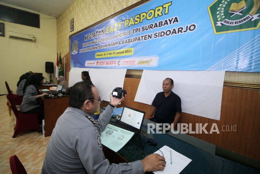 Immigration officers take pictures of Hajj candidates during passport making service at Sidoarjo Ministry Office, East Java, Wednesday (17/1/2024). The Special Class I Immigration Office Surabaya held a ball for issuing passports to 800 pilgrims of Hajj candidates from Sidoarjo Regency.