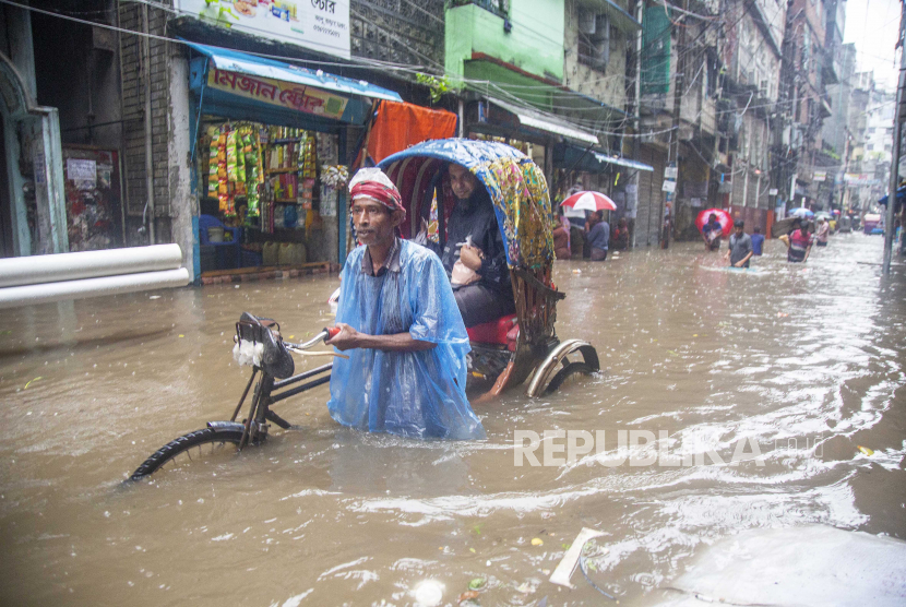 Orang-orang duduk di atas becak di jalan banjir di Dhaka, Bangladesh, 21 Juli 2020.  Bangladesh menjadi negara ketujuh paling berisiko dalam indeks risiko iklim global.
