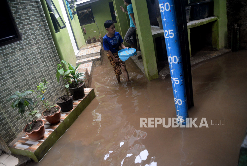 Warga melintasi banjir yang merendam kawasan Kebon Pala, Kampung Melayu, Jatinegara, Jakarta. Warga RW 04 Kebon Pala membersihkan rumah mereka dari lumpur sisa banjir.